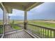 Covered deck with wooden railing and beautiful views of the surrounding landscape and greenery at 3166 Newfound Lake Rd, Berthoud, CO 80513