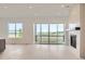 Open-concept living space with sleek kitchen, expansive island, fireplace, and outdoor access at 3166 Newfound Lake Rd, Berthoud, CO 80513