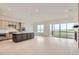 Open-concept living space with sleek kitchen, expansive island, fireplace, and outdoor access at 3166 Newfound Lake Rd, Berthoud, CO 80513