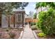 Charming backyard featuring a stone pathway, lush greenery, wooden fence, and privacy screen at 1518-1520 S Sherman St, Denver, CO 80210