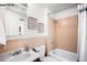 Bathroom with pink tile shower, vanity with white sink, mirror, and framed floral pictures at 1518-1520 S Sherman St, Denver, CO 80210