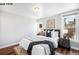 Bright bedroom with hardwood floors, two windows and a comfortable bed dressed in white linens with gray accents at 1518-1520 S Sherman St, Denver, CO 80210