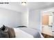 A bedroom with ensuite bathroom and view of the hall, featuring neutral walls and hardwood floors at 1518-1520 S Sherman St, Denver, CO 80210
