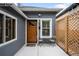 Inviting front porch with gray siding, a wooden front door, and a cozy seating area at 1518-1520 S Sherman St, Denver, CO 80210
