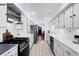 Galley kitchen features white cabinets, updated appliances, and tile flooring at 1518-1520 S Sherman St, Denver, CO 80210