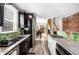 Modern kitchen with stainless steel appliances, dark cabinets, and stylish tiled backsplash with an open layout at 1518-1520 S Sherman St, Denver, CO 80210