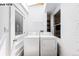 Laundry room featuring a stacked washer and dryer, a door to the outside, and a window for natural light at 1518-1520 S Sherman St, Denver, CO 80210