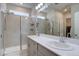 Bright bathroom boasts double sinks, a large mirror, and a glass-enclosed shower with tiled walls at 2785 Black Hawk Pl, Brighton, CO 80601