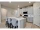 Bright kitchen with an island, white cabinets, stainless appliances and a view to another door at 2785 Black Hawk Pl, Brighton, CO 80601