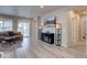 Bright living room featuring hardwood floors, a modern fireplace, and sliding glass doors at 2785 Black Hawk Pl, Brighton, CO 80601