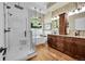 Spa-like bathroom with glass-enclosed shower, soaking tub, and wood cabinets with stone countertops at 3311 Klondike Pl, Castle Rock, CO 80108