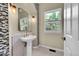 Charming bathroom with stylish herringbone tile, a pedestal sink, and vintage-inspired lighting at 3311 Klondike Pl, Castle Rock, CO 80108