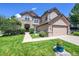 Stunning home exterior with stone accents, an arched entrance, and manicured landscaping at 3311 Klondike Pl, Castle Rock, CO 80108