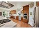 Spacious kitchen with stainless steel appliances, wood cabinets, and adjacent dining area at 3311 Klondike Pl, Castle Rock, CO 80108