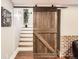 Basement staircase featuring a rustic sliding barn door and hardwood floors at 325 S High St, Denver, CO 80209