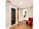 Bright basement with a unique red chair, brickwork accents, and wood-look flooring at 325 S High St, Denver, CO 80209