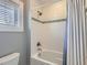 Clean bathroom featuring white subway tiles, a shower-tub combo, and bright natural light at 325 S High St, Denver, CO 80209