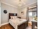 Cozy bedroom with hardwood floors, neutral paint, crown molding, a chandelier and a stylish double bed at 325 S High St, Denver, CO 80209