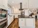 Spacious kitchen with stainless appliances, white cabinetry, hardwood flooring and a view to the living area at 325 S High St, Denver, CO 80209