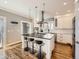 Bright kitchen features a center island, stainless steel appliances, pendant lighting and hardwood floors at 325 S High St, Denver, CO 80209