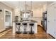Bright kitchen features a center island, stainless steel appliances, pendant lighting and hardwood floors at 325 S High St, Denver, CO 80209