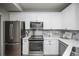 White kitchen features stainless steel appliances and marble backsplash at 6436 Silver Mesa Dr # E, Highlands Ranch, CO 80130