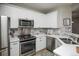 Modern kitchen with white cabinets, stainless steel appliances, and marble backsplash at 6436 Silver Mesa Dr # E, Highlands Ranch, CO 80130