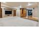 Finished basement with large tv, wooden storage cabinets, and light carpeted flooring at 10375 Lions Heart, Lone Tree, CO 80124
