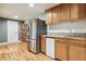 Wet bar with stainless steel refrigerator, wooden cabinets, and light hardwood flooring at 10375 Lions Heart, Lone Tree, CO 80124