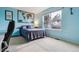 Comfortable bedroom featuring bright blue walls, carpeted floors, and a large window at 10375 Lions Heart, Lone Tree, CO 80124