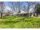 Scenic view of the backyard showing an expansive green lawn and mature trees at 33 Canongate Ln, Highlands Ranch, CO 80130