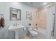 Clean bathroom with a pedestal sink, soaking tub, and light tile, a blend of comfort and style at 33 Canongate Ln, Highlands Ranch, CO 80130