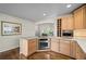 Bright kitchen featuring stainless steel oven, light wood cabinets, and stone countertops at 33 Canongate Ln, Highlands Ranch, CO 80130