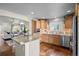 Open-concept kitchen featuring a breakfast bar, light wood cabinetry, and stainless steel appliances at 33 Canongate Ln, Highlands Ranch, CO 80130
