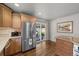 Bright kitchen featuring stainless steel refrigerator, light wood cabinets, and sliding glass doors at 33 Canongate Ln, Highlands Ranch, CO 80130