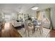 Open-concept living room and dining area with hardwood floors, fireplace, ceiling fan, and large windows at 33 Canongate Ln, Highlands Ranch, CO 80130