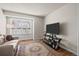 Cozy living room featuring natural light, neutral paint, hardwood floors, and television at 33 Canongate Ln, Highlands Ranch, CO 80130