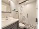 Modern bathroom featuring a glass enclosed shower with safety grab bars and a gray vanity with a white sink at 20370 E 52Nd Ave, Denver, CO 80249