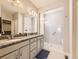 Bright bathroom with double sinks, granite countertops, and tiled walk-in shower at 20370 E 52Nd Ave, Denver, CO 80249