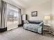Bright bedroom with large window, gray carpet, daybed with nautical-themed pillows, and a small side table with lamp at 20370 E 52Nd Ave, Denver, CO 80249