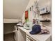 Attic craft room featuring white desk, sewing machine, and storage shelves with pegboard full of supplies at 20370 E 52Nd Ave, Denver, CO 80249