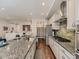Open kitchen with stainless steel appliances, granite counters, and spacious pantry at 20370 E 52Nd Ave, Denver, CO 80249