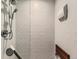Walk-in shower featuring textured wall tiles, a mounted seat, and a detachable showerhead at 20370 E 52Nd Ave, Denver, CO 80249