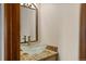 Stylish bathroom features a modern glass bowl sink, granite countertop, and decorative mirror at 7192 Pinewood Dr, Evergreen, CO 80439
