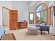 Bright bedroom with a large arched window and cozy sitting area at 7192 Pinewood Dr, Evergreen, CO 80439