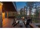 A twilight view of the wooden deck shows a fire pit and seating at 7192 Pinewood Dr, Evergreen, CO 80439