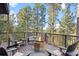 An outdoor deck features a fire pit, comfortable seating, and views of the surrounding mountains and forest at 7192 Pinewood Dr, Evergreen, CO 80439