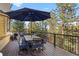 A wide deck features outdoor dining with an umbrella, seating, and forest views at 7192 Pinewood Dr, Evergreen, CO 80439