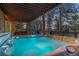 Relaxing hot tub on a covered deck with forest views, perfect for outdoor enjoyment at 7192 Pinewood Dr, Evergreen, CO 80439