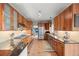 Bright kitchen with stainless appliances, wood cabinetry, tile floors, and eat-in counter at 7192 Pinewood Dr, Evergreen, CO 80439